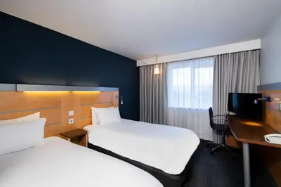 a hotel room with two beds and a desk at Holiday Inn Express Hamilton by IHG in Hamilton