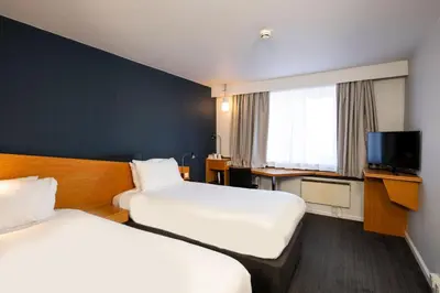 a hotel room with two beds and a tv at Holiday Inn Express Hamilton by IHG in Hamilton
