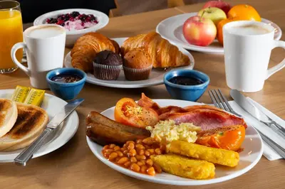 a table with plates of breakfast food on it at Holiday Inn Express Hamilton by IHG in Hamilton