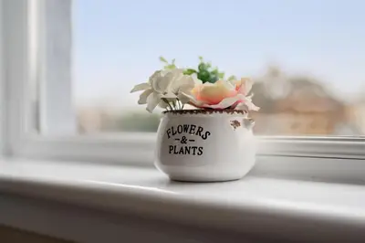 a vase with flowers in it sitting on a window sill at Queensferry Guest house in Rosyth