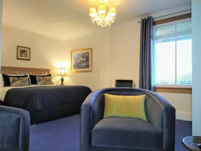 a bedroom with a bed and a couch and a chair at Rhins of Galloway in Cairnryan
