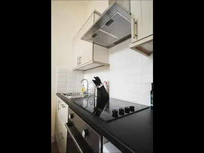 a kitchen with a black counter top with a sink at Cedar Apartment in Helensburgh