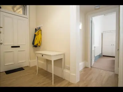 a room with a white door and a white table at Cedar Apartment in Helensburgh