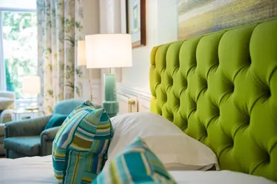 a bed with a green headboard in a room at One Devonshire Gardens a Hotel Du Vin in Glasgow