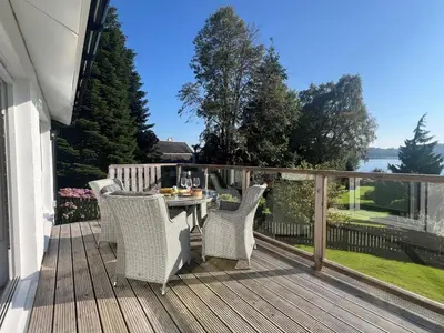 a patio with a table and chairs on a deck at Dunbheag Cottage in Strone