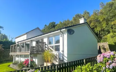 a large white house with a balcony at Dunbheag Cottage in Strone