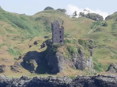 an old castle on a hill with a mountain at Oban Youth Hostel in Oban