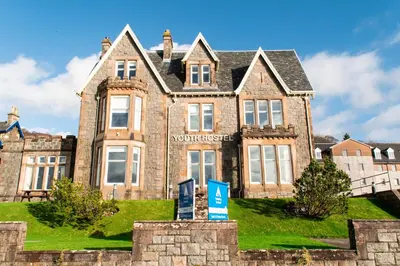 a large brick building with a sign in front of it at Oban Youth Hostel in Oban