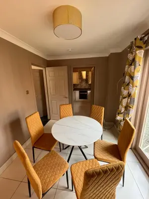 a dining room with a white table and chairs at Retreat at The Knowe Auchincruive Estate in Ayr