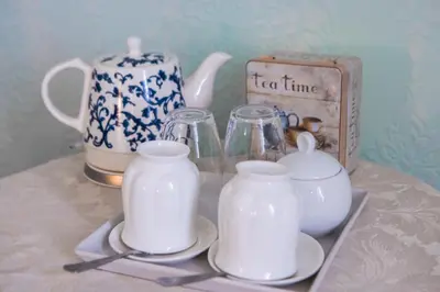 a tray with three glass jars and a tea set at Drumfearne Guesthouse & Tearoom in Carradale