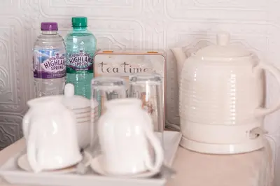 a shelf with several cups and bottles of milk at Drumfearne Guesthouse & Tearoom in Carradale