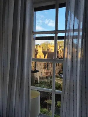 a window with a view of a castle at Dean Village Cottage in Edinburgh