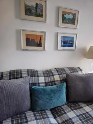 a couch in a living room with pictures on the wall at Dean Village Cottage in Edinburgh