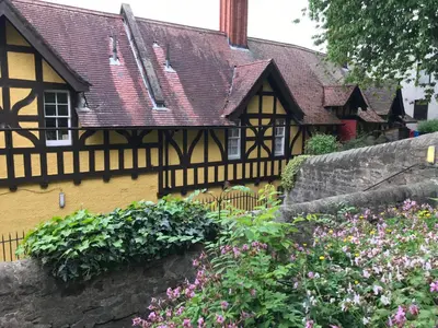 a yellow and black house with a bunch of flowers at Dean Village Cottage in Edinburgh
