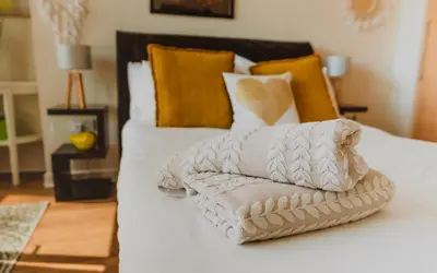 a pile of towels sitting on top of a bed at Lovely Bohemian Apartment in Heart of City Life in Glasgow