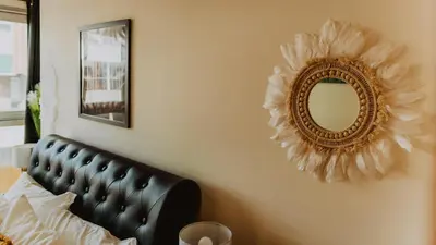 a mirror on a wall next to a bed at Lovely Bohemian Apartment in Heart of City Life in Glasgow
