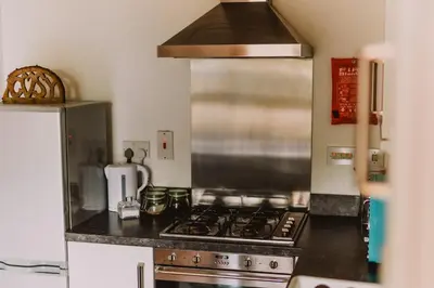 a kitchen with a stove and a refrigerator at Lovely Bohemian Apartment in Heart of City Life in Glasgow
