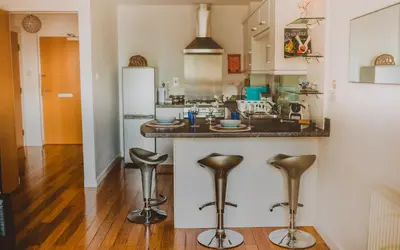 a kitchen with a counter and stools at Lovely Bohemian Apartment in Heart of City Life in Glasgow