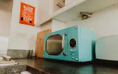 a blue microwave sitting on top of a kitchen counter at Lovely Bohemian Apartment in Heart of City Life in Glasgow