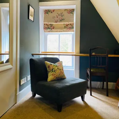 a chair with a pillow in a room with a window at Knockderry Country House Hotel in Cove