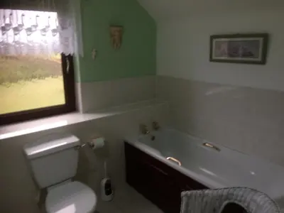 a bathroom with a tub and a toilet and a sink at Woodcockfaulds House in Stirling
