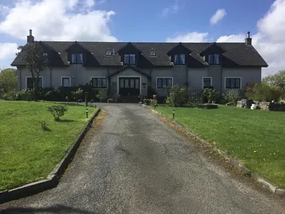 a large white house with a road in front of it at Woodcockfaulds House in Stirling