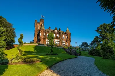 an old castle on top of a grassy hill at Sherbrooke Castle Hotel in Glasgow