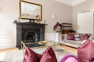 a living room with a fireplace and a mirror at JOIVY Ultra Luxe Home near Princes Street in Edinburgh
