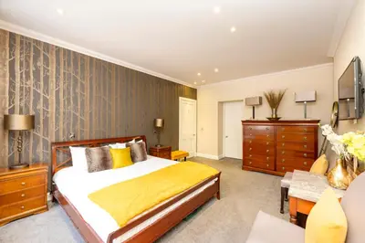 a bedroom with a bed with a yellow blanket at JOIVY Ultra Luxe Home near Princes Street in Edinburgh