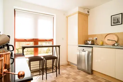 a kitchen with two stools and a counter top at JOIVY Gorgeous Flat near The Scotland Gallery in Edinburgh