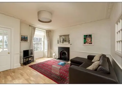 a living room with a couch and a fireplace at JOIVY Boutique Apt with Patio in New Town in Edinburgh
