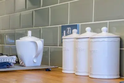 a group of four white containers sitting on a counter at JOIVY Stylish Apt in Trendy New Town Location in Edinburgh