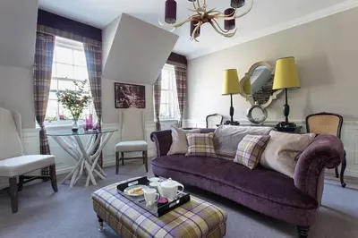 a living room with a purple couch and a table at JOIVY Charming Nest for Two with Castle View in Edinburgh