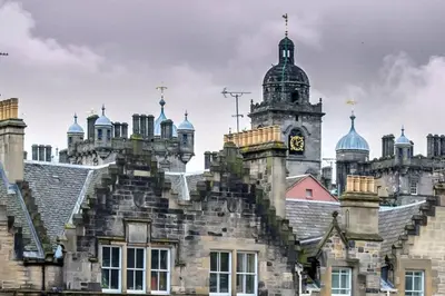 an old building with a clock tower on top of it at JOIVY Charming Nest for Two with Castle View in Edinburgh