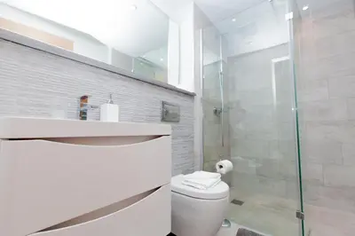 a bathroom with a toilet and a glass shower at Luxurious Central Edinburgh Apartment - Sleeps 6 in Edinburgh