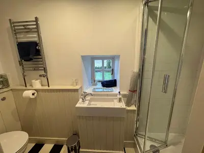 a bathroom with a sink and a shower and a toilet at Charming cottage with loch and hill views nr Edinburgh in Cobbinshaw