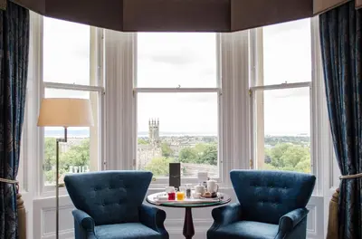 a room with two chairs and a table in front of a window at The Bonham in Edinburgh