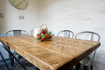 a wooden table with a basket of flowers on it at The Falls Of Dochart Inn in Killin
