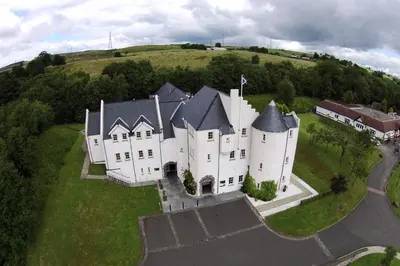 an aerial view of a large white castle on a hill at Glenskirlie Castle Hotel in Banknock