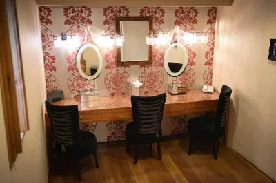 a dressing room with a vanity with mirrors and chairs at Glenskirlie Castle Hotel in Banknock