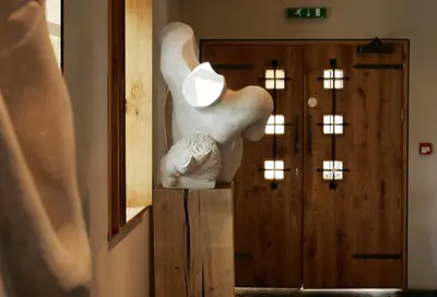 a white statue sitting on a stand in front of a door at Glenskirlie Castle Hotel in Banknock