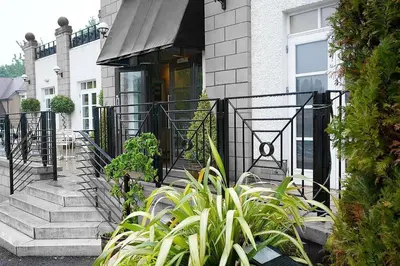 a house with stairs and plants in front of it at Park Hotel in Falkirk