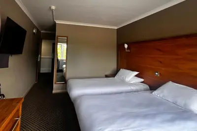 a room with two beds and a television in it at Park Hotel in Falkirk