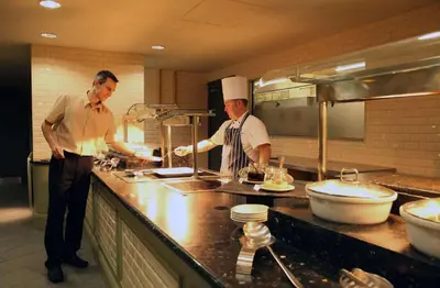 two chefs standing in a kitchen preparing food at Doubletree By Hilton Glasgow Strathclyde in Bellshill