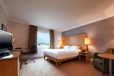 a hotel room with a bed and a flat screen tv at Doubletree By Hilton Glasgow Strathclyde in Bellshill
