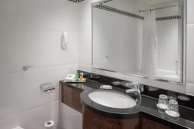 a bathroom with a sink and a mirror at Glasgow Grosvenor Hotel in Glasgow