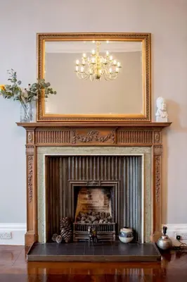 a fireplace with a mirror above it in a living room at JOIVY Spacious Apt in New Town Prime Location in Edinburgh