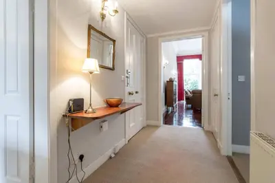 a hallway with a table with a lamp on it at JOIVY Spacious Apt in New Town Prime Location in Edinburgh