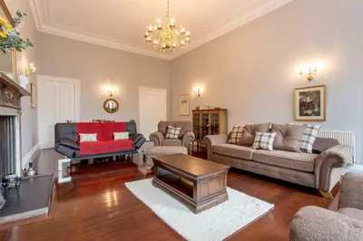 a living room with furniture and a chandelier at JOIVY Spacious Apt in New Town Prime Location in Edinburgh