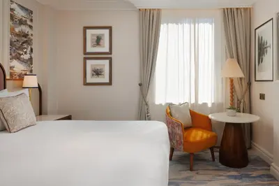 a hotel room with a bed and a chair and a window at The Caledonian Edinburgh, Curio Collection by Hilton in Edinburgh